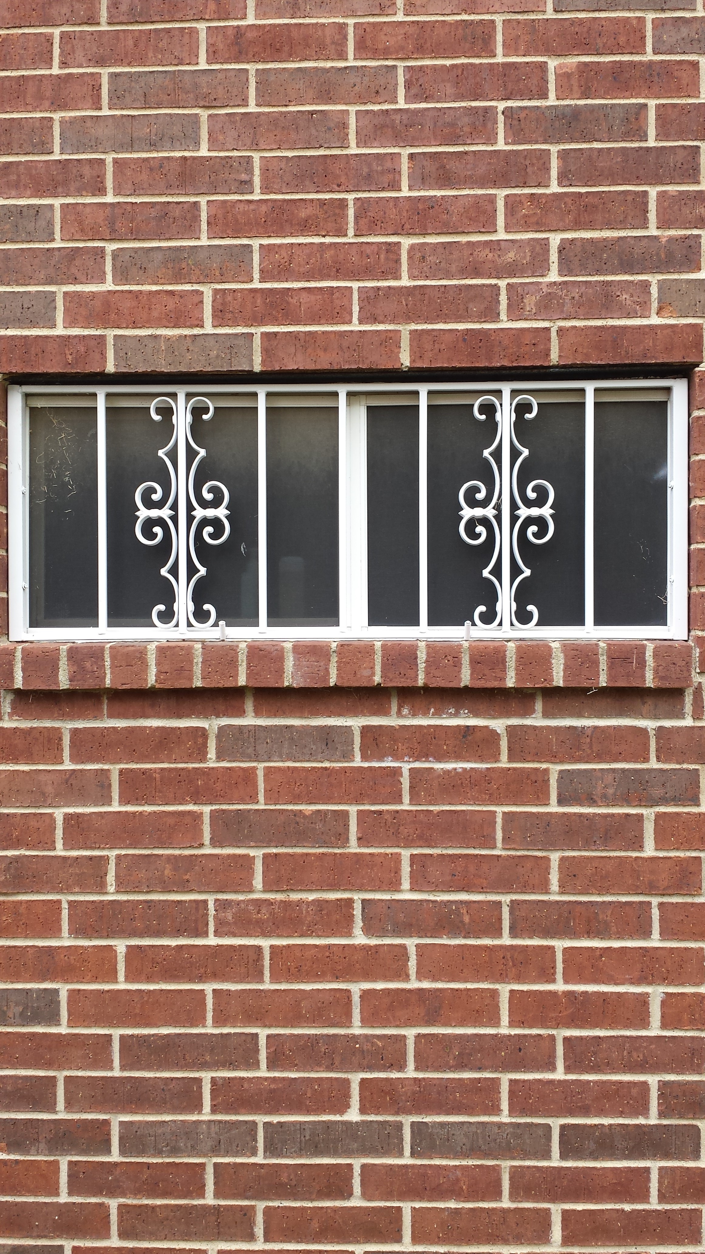 White decorative window burglar bars with ornamental scrollwork
