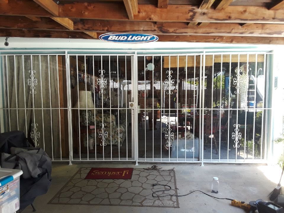 White multi-panel patio door security gate with decorative scrollwork